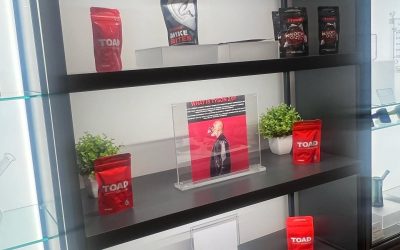 Shelves with red bags, a graphic image, and small plants on display at the Tyson 2.0 Global NJ Tour event.